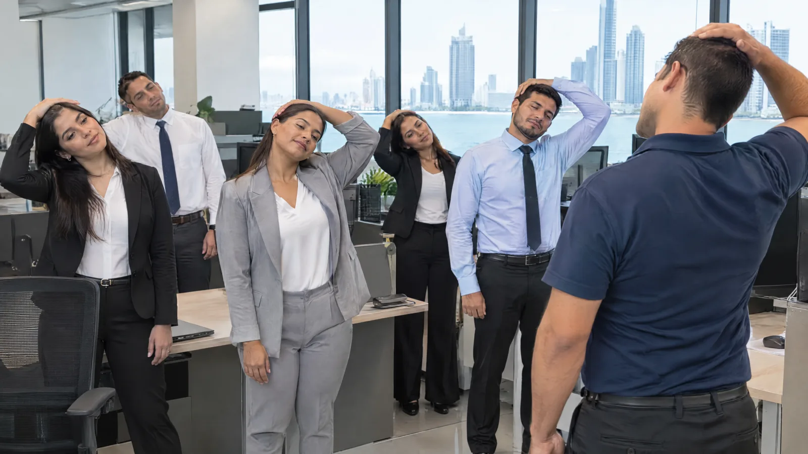 Equipo de back office estirando el cuello junto a sus escritorios