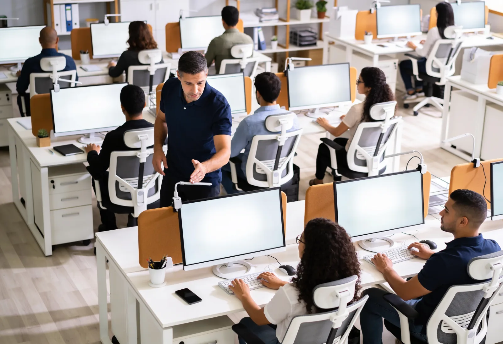 THA instructor helping employees adjust their posture at the computer